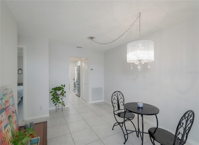 dining area featuring light tile patterned floors and an inviting chandelier