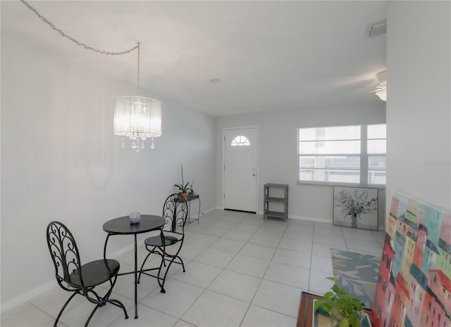 dining space with light tile patterned floors and an inviting chandelier