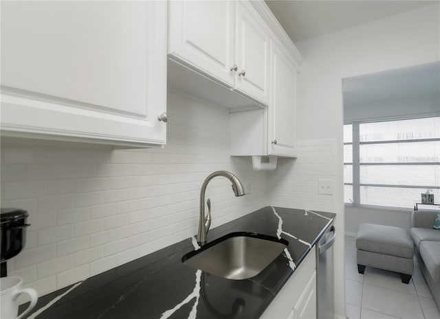 2960 59th St S Unit 509, Gulfport, FL 33707 - kitchen featuring a sink, white cabinetry, decorative backsplash, light tile patterned floors, and stainless steel dishwasher