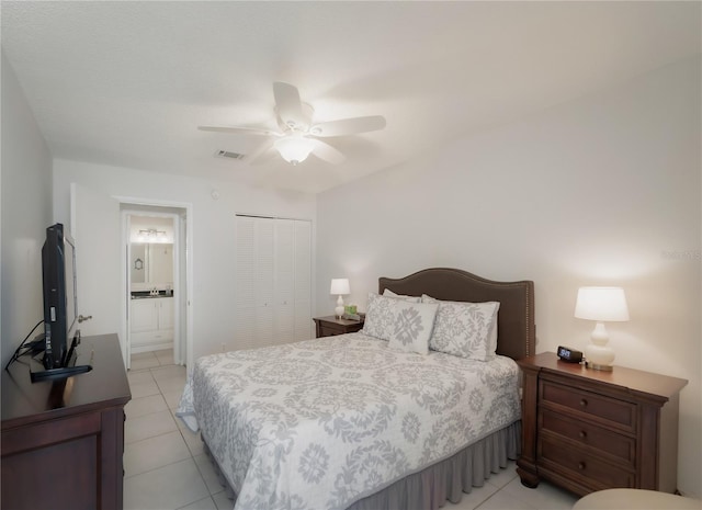 bedroom featuring light tile patterned floors, connected bathroom, a closet, and ceiling fan