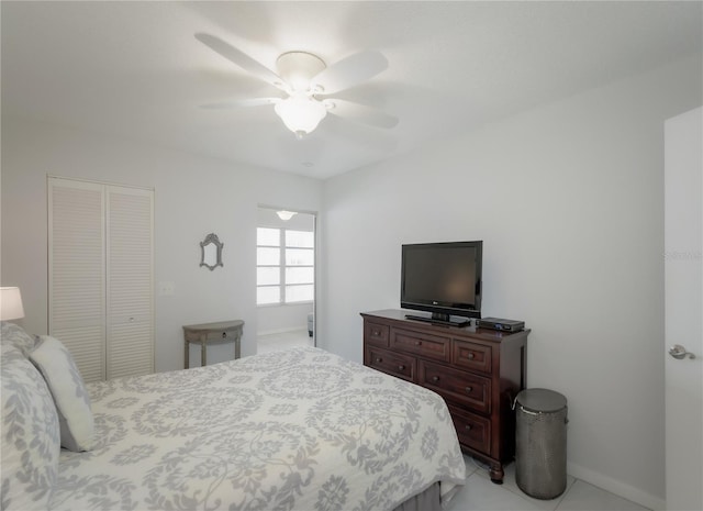 tiled bedroom with ceiling fan and a closet