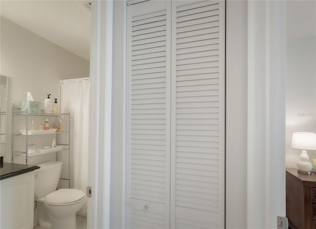 bathroom with curtained shower and toilet