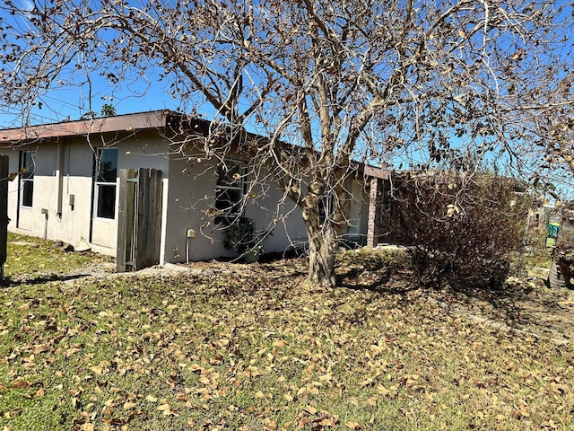 view of side of home with a yard