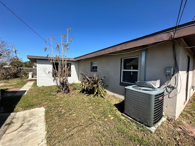 back of house with central air condition unit, a patio area, and a yard