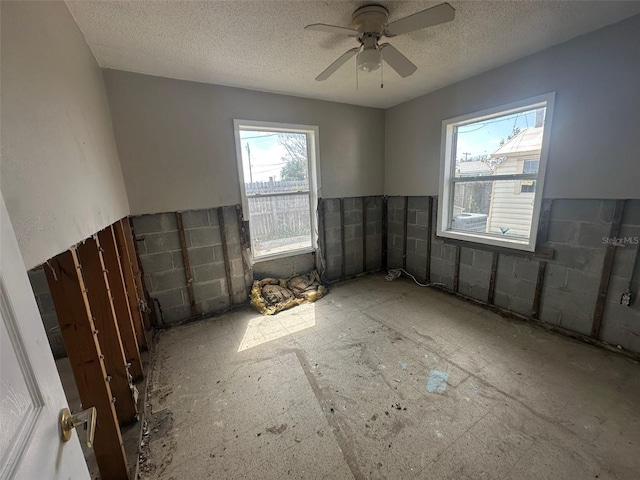 unfurnished room featuring a textured ceiling and ceiling fan