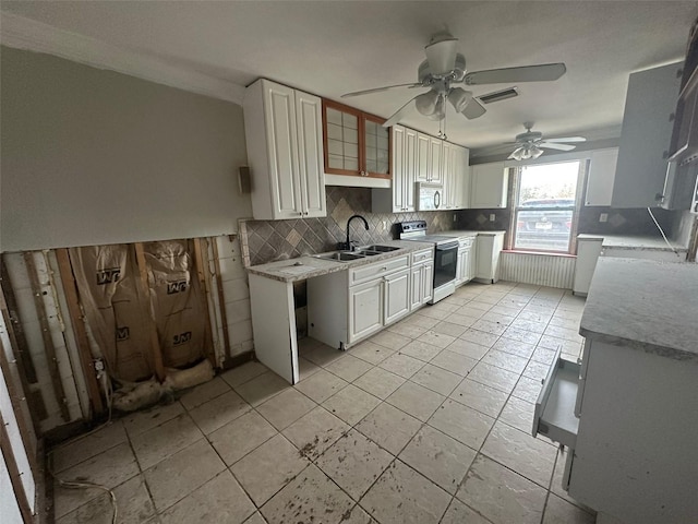 kitchen featuring decorative backsplash, sink, white range with electric cooktop, white cabinets, and ceiling fan