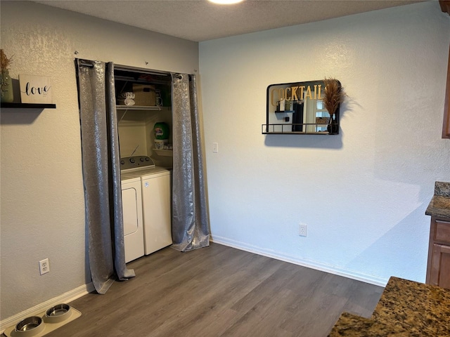 hall featuring hardwood / wood-style flooring, a textured ceiling, and separate washer and dryer