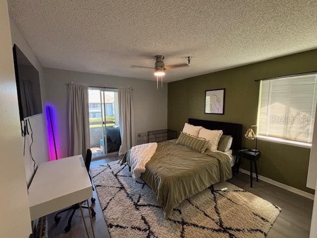 bedroom featuring hardwood / wood-style floors, access to exterior, a textured ceiling, and ceiling fan