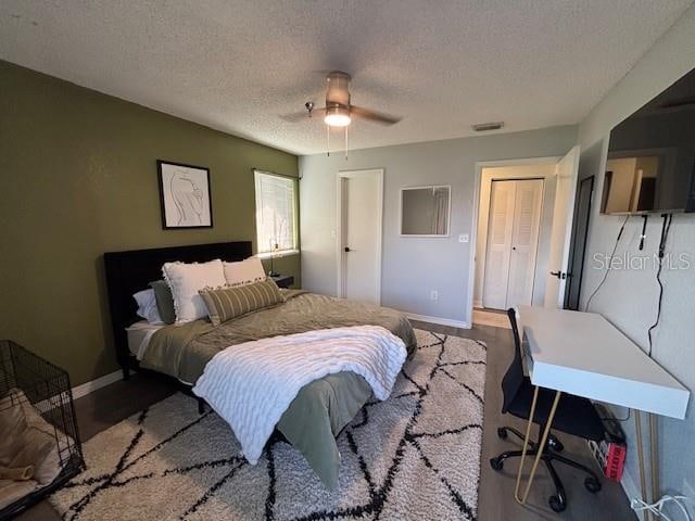 bedroom with a textured ceiling, light wood-type flooring, and ceiling fan