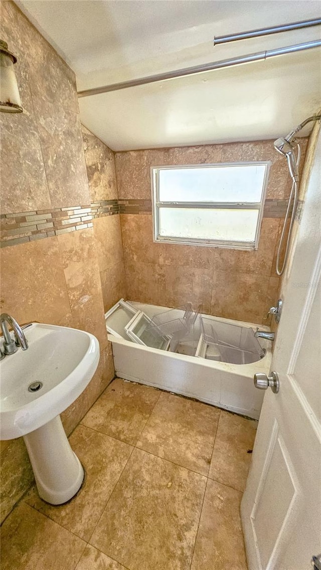 bathroom with tiled shower / bath combo, tile walls, and tile patterned flooring