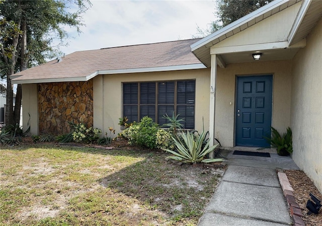 view of exterior entry with a lawn