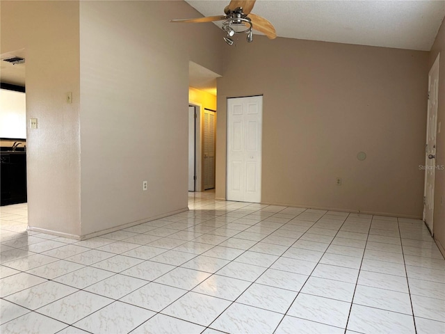 tiled spare room featuring high vaulted ceiling, sink, and ceiling fan