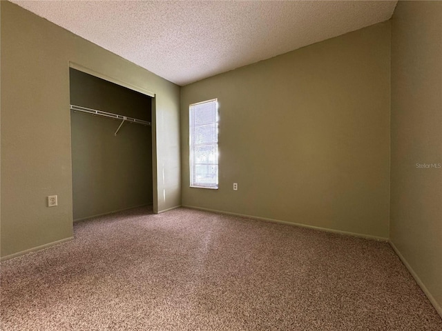 unfurnished bedroom featuring a closet, a textured ceiling, and carpet floors