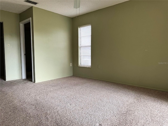 carpeted empty room with a textured ceiling and ceiling fan