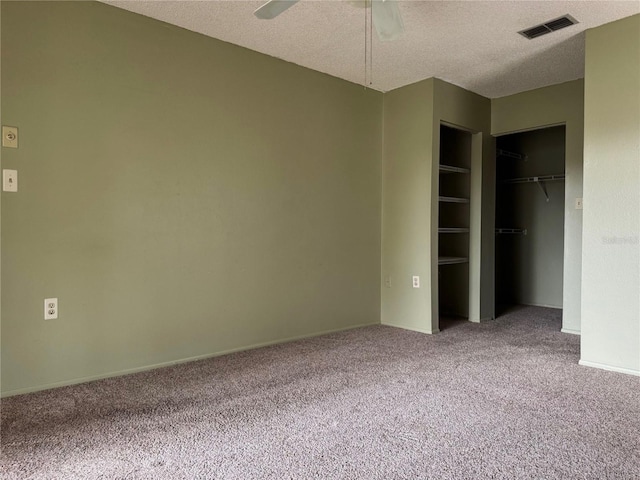 unfurnished bedroom featuring carpet floors, a textured ceiling, and ceiling fan