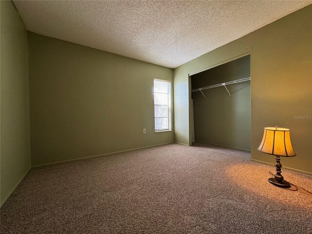 unfurnished bedroom with a closet, a textured ceiling, and carpet floors