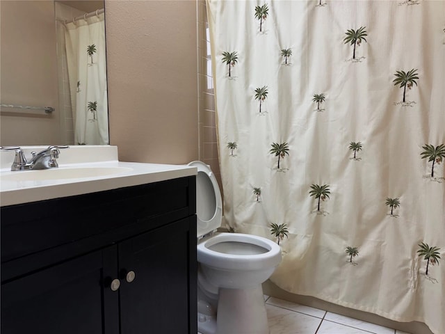 bathroom with toilet, curtained shower, vanity, and tile patterned floors