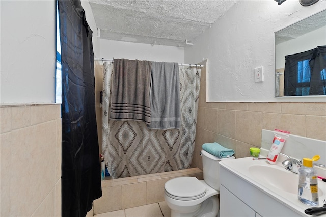 205 Santurce Ave, North Port, FL 34287 - bathroom featuring toilet, tile walls, a textured ceiling, wainscoting, and vanity