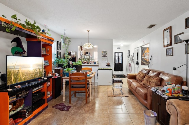 tiled living room featuring a textured ceiling