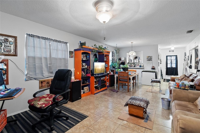 office area with a textured ceiling and light tile patterned floors