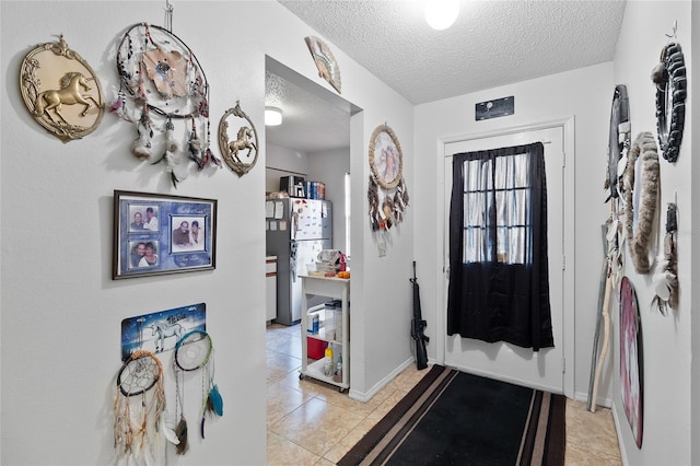 tiled foyer featuring a textured ceiling