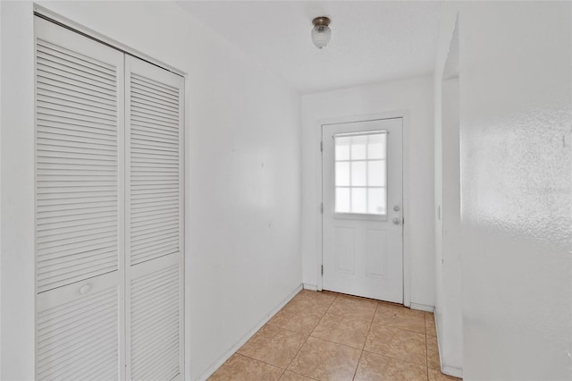 doorway with light tile patterned floors