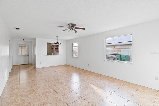 unfurnished room with ceiling fan with notable chandelier, a textured ceiling, and light tile patterned floors