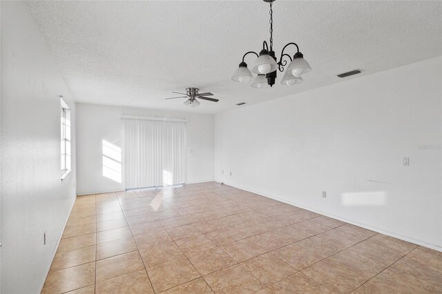 tiled empty room featuring ceiling fan with notable chandelier and a textured ceiling