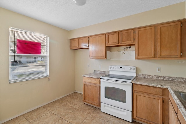 kitchen featuring light tile patterned flooring, a textured ceiling, and white range with electric stovetop