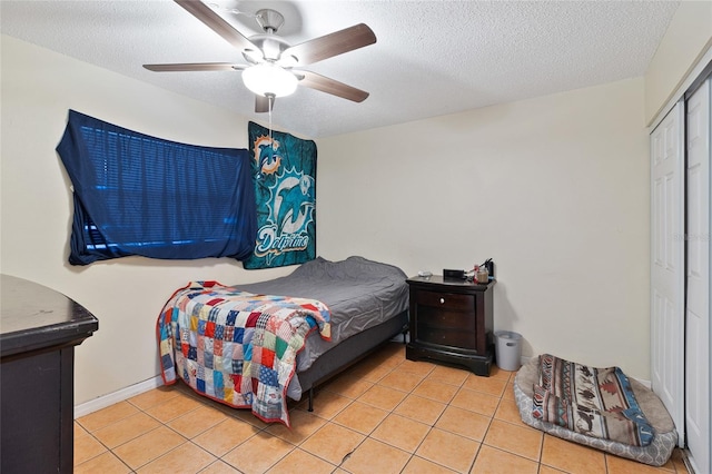 bedroom with a textured ceiling, a closet, and light tile patterned floors