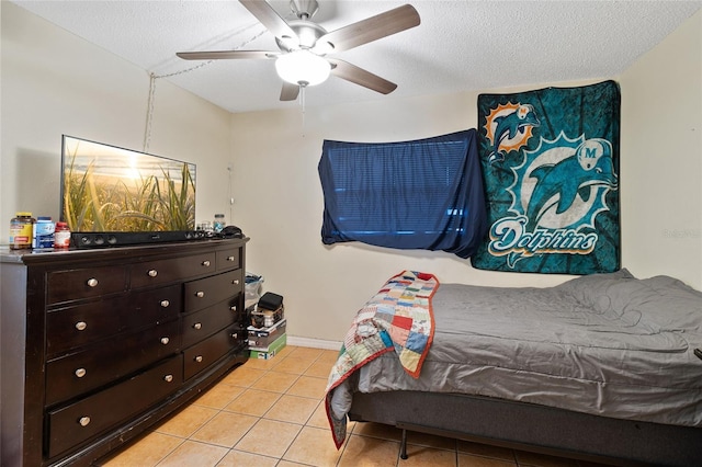 tiled bedroom with ceiling fan and a textured ceiling