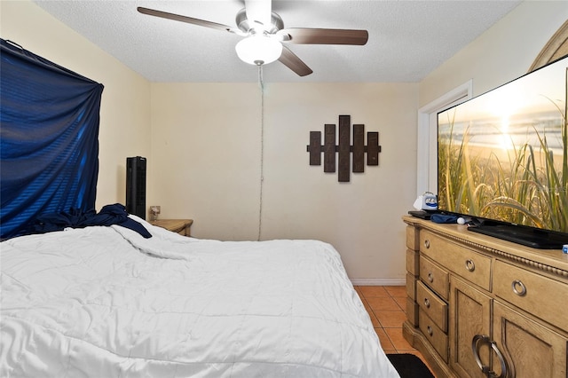 bedroom with ceiling fan, a textured ceiling, and light tile patterned floors