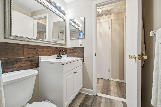 bathroom with vanity, toilet, wood-type flooring, and a textured ceiling