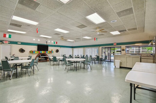 dining space with a drop ceiling and ceiling fan