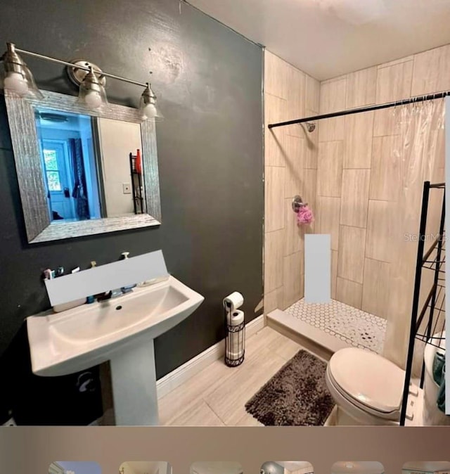 bathroom featuring toilet and a tile shower