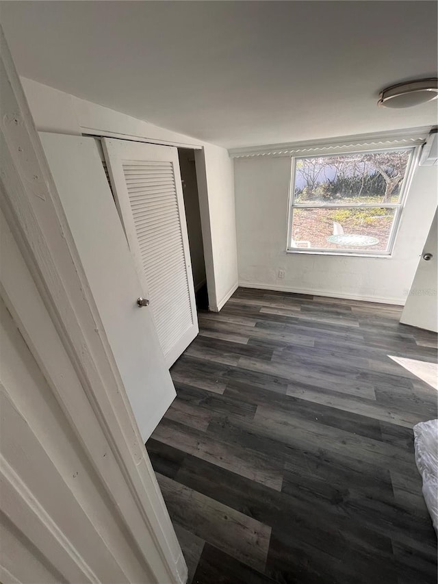 unfurnished bedroom with a closet and dark hardwood / wood-style floors