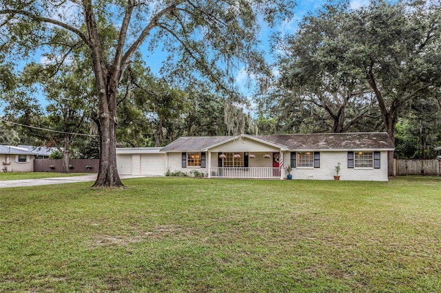 ranch-style house with covered porch, a front lawn, and a garage