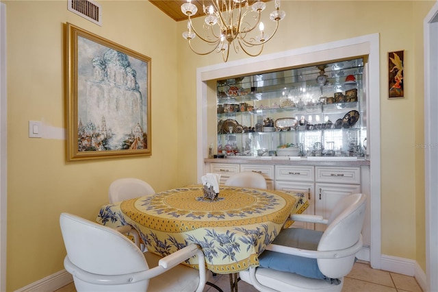 dining room with light tile patterned flooring and a notable chandelier