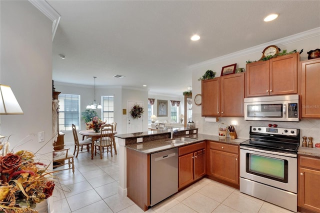 kitchen with stainless steel appliances, brown cabinets, a sink, and crown molding