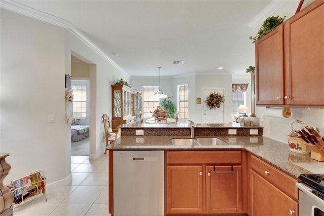kitchen featuring light stone counters, a peninsula, a wealth of natural light, stainless steel appliances, and a sink