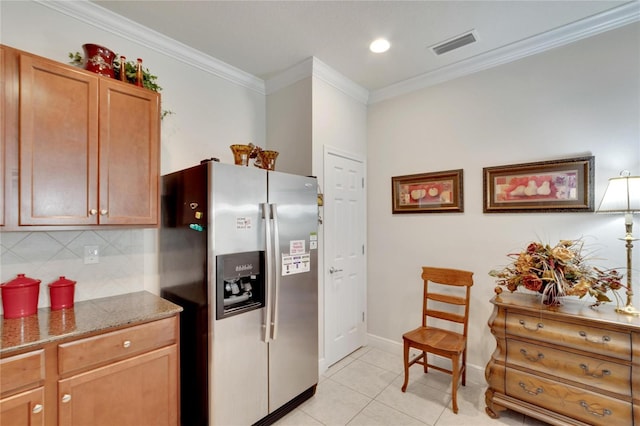 kitchen with decorative backsplash, ornamental molding, light tile patterned floors, stone counters, and stainless steel fridge with ice dispenser