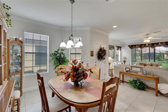 tiled dining space with a wealth of natural light, ceiling fan with notable chandelier, and ornamental molding