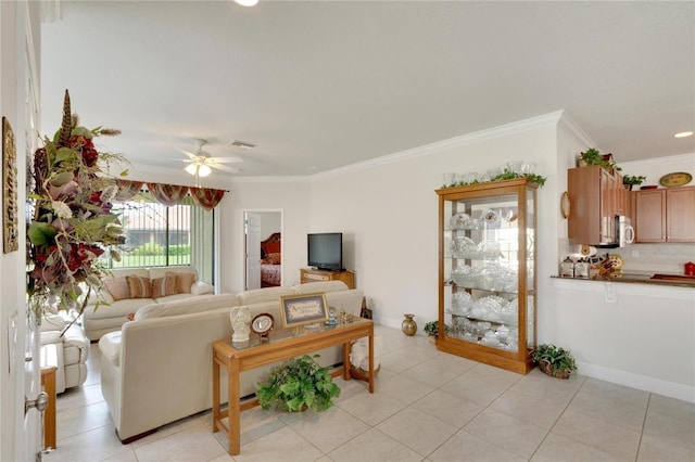 living room featuring light tile patterned floors, baseboards, visible vents, a ceiling fan, and crown molding