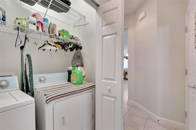 washroom featuring baseboards, independent washer and dryer, laundry area, and light tile patterned flooring