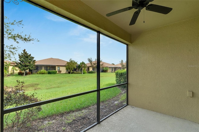 unfurnished sunroom with ceiling fan