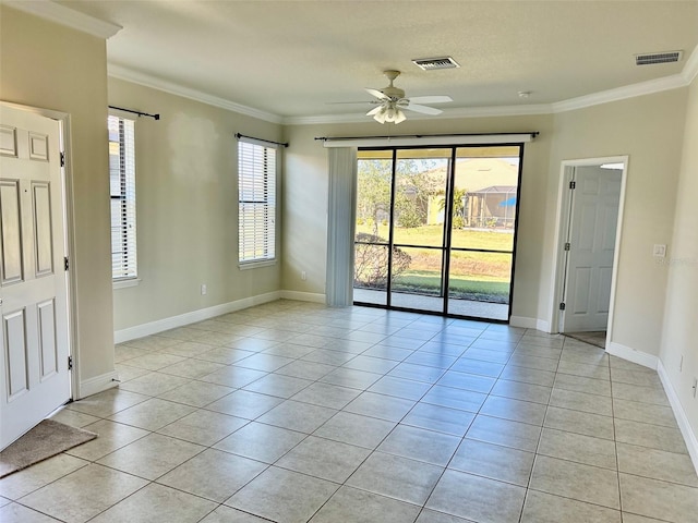 spare room with ceiling fan, crown molding, and light tile patterned flooring