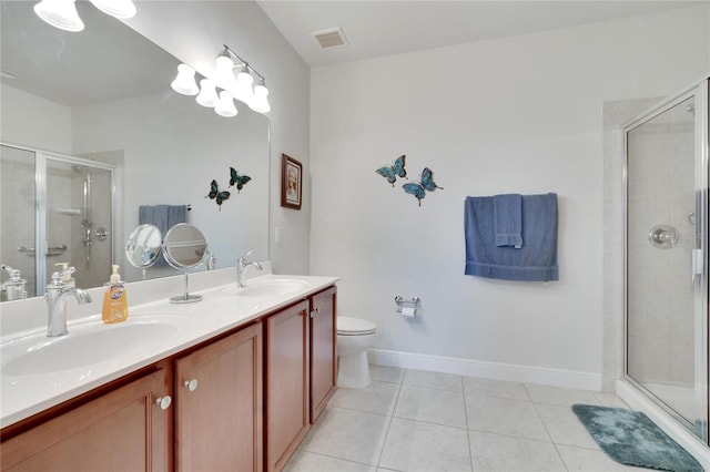 bathroom with tile patterned flooring, vanity, a shower with shower door, and toilet