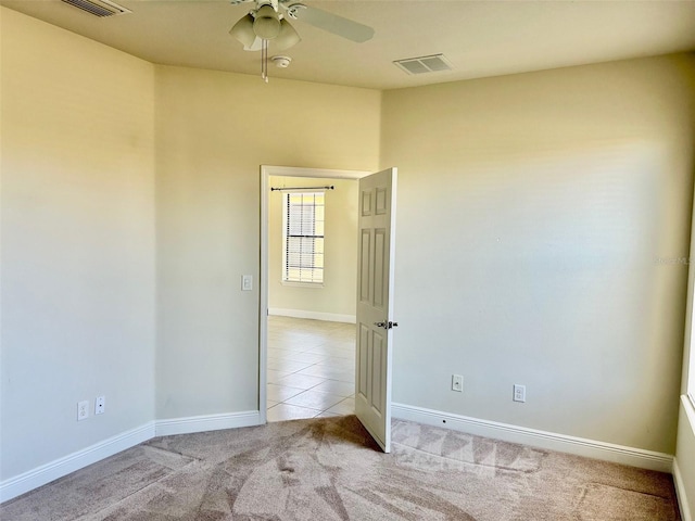 unfurnished room with ceiling fan and light carpet