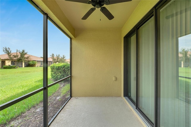 unfurnished sunroom with ceiling fan