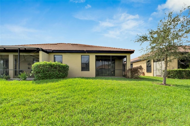 rear view of house featuring a lawn and a lanai